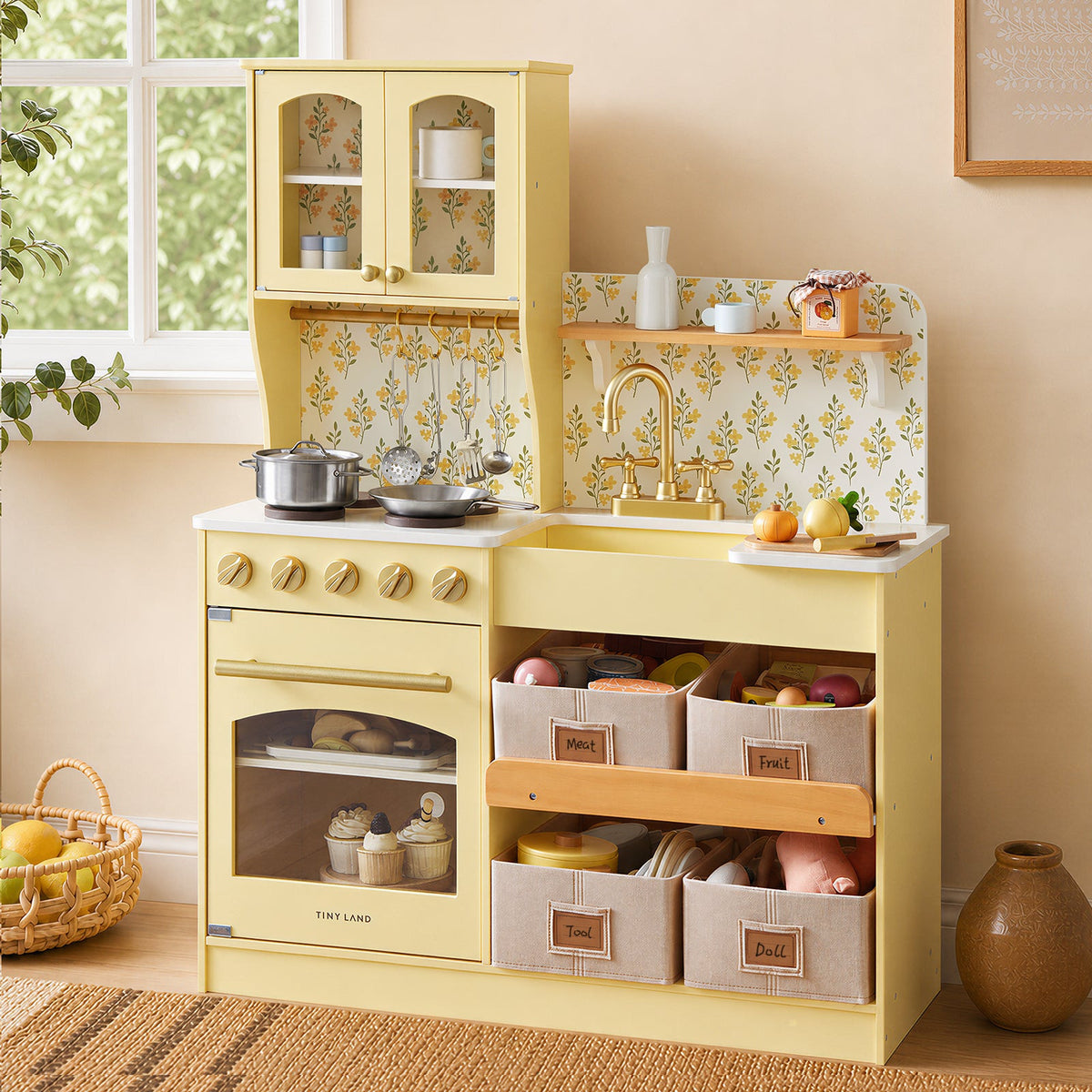 Yellow wooden play kitchen with open doors, floral backsplash, and stocked countertop
