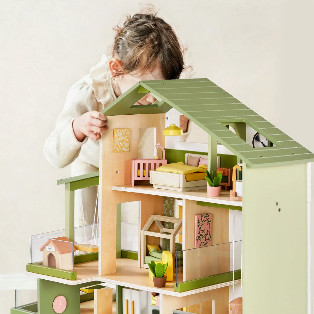 Green Tiny Land dollhouse with furnished rooms and slanted roof, front view