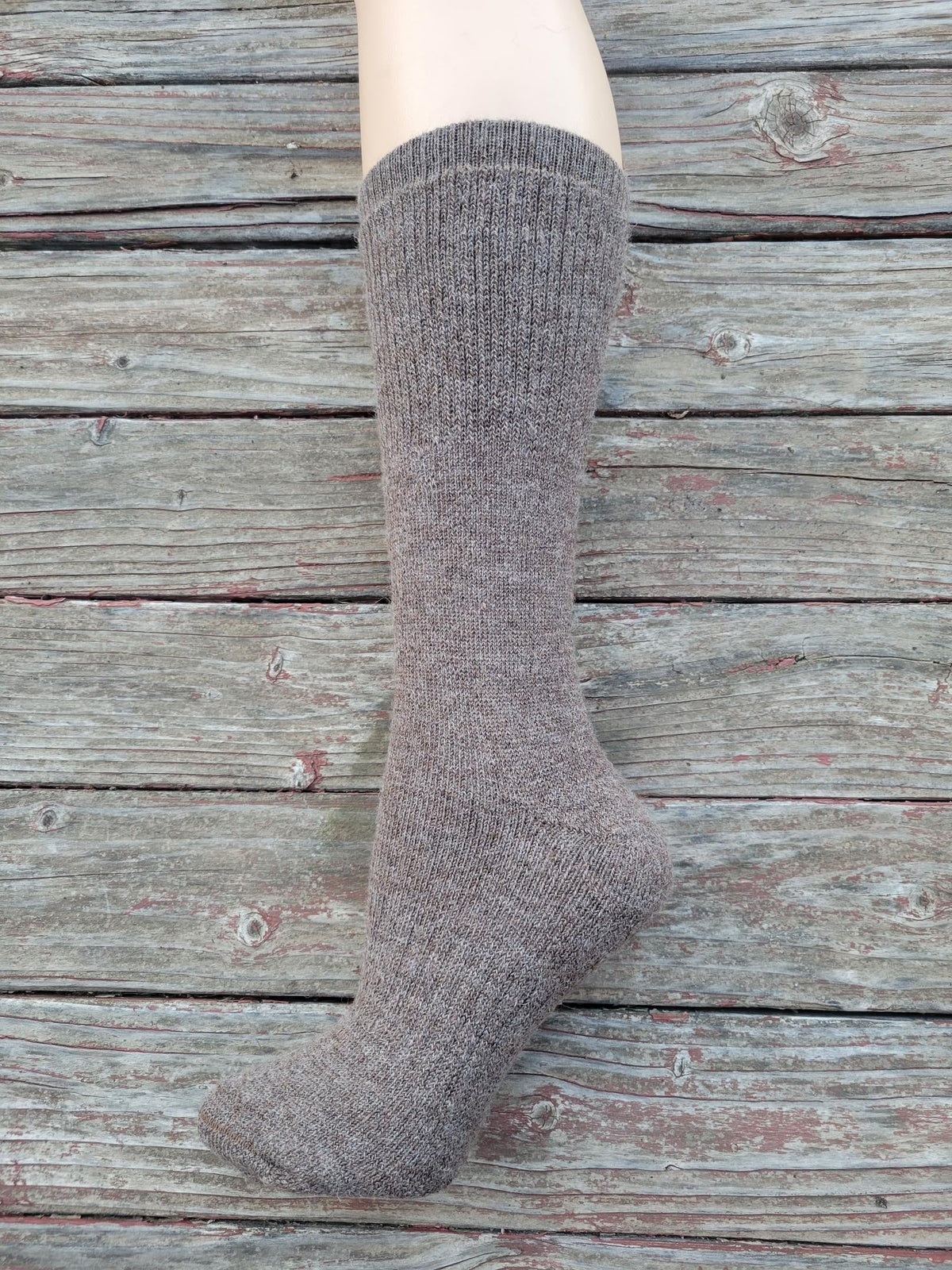 Dark heather gray crew sock on leg, knit texture and ribbed cuff detail.