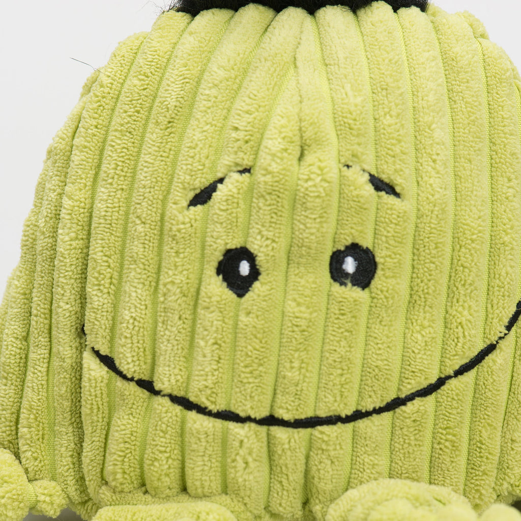 Close-up of lime green plush octopus face with stitched smile and black button eyes