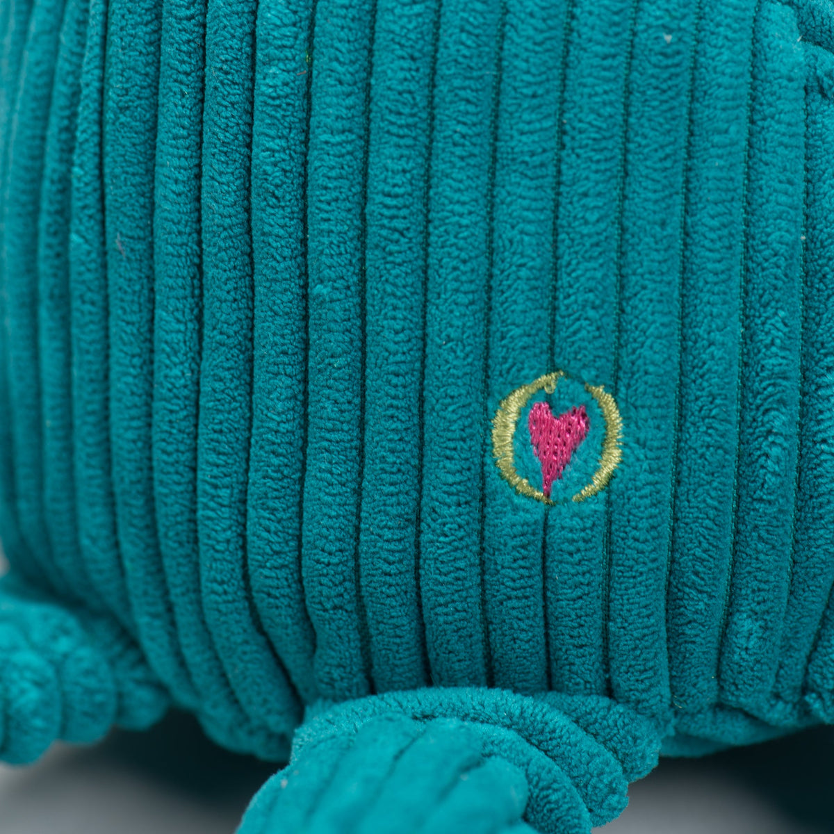 Teal plush octopus side with small embroidered heart patch