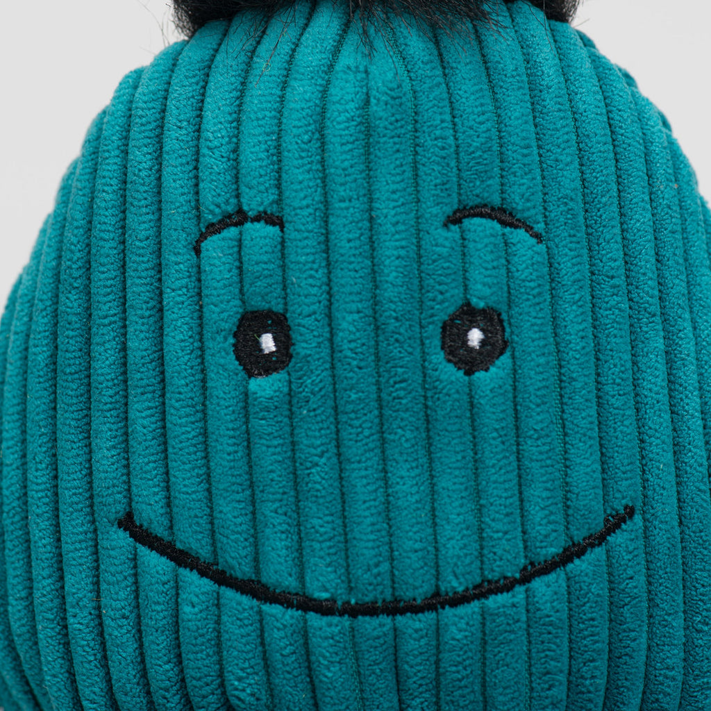 Close-up of teal plush octopus face with stitched smile and black button eyes