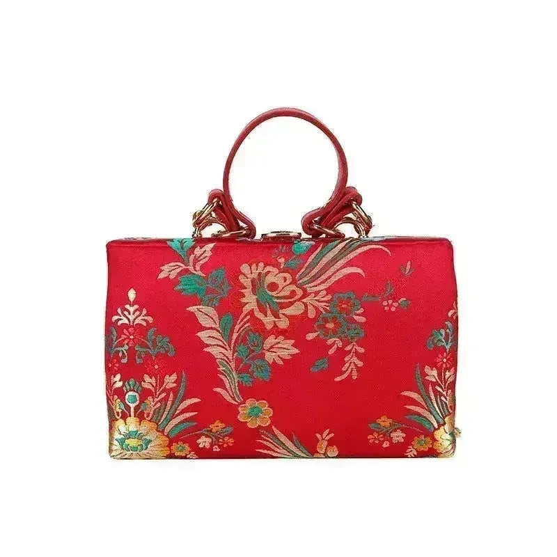 Red floral clutch bag with gold-tone hardware and loop top handles