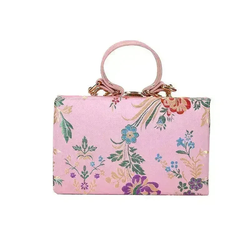 Floral clutch bag in light pink with colorful botanical print and loop top handles