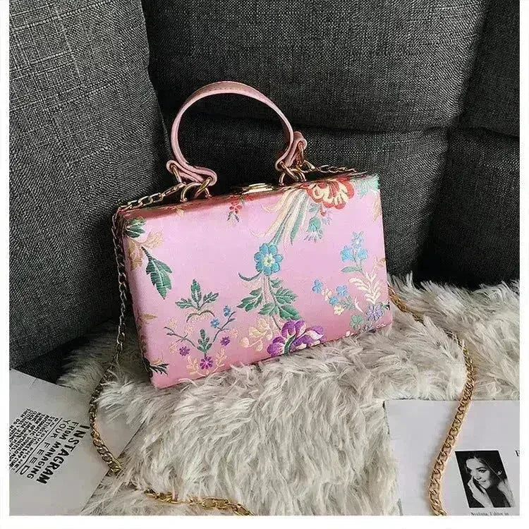 Light pink floral clutch bag with gold chain strap and top loop handles