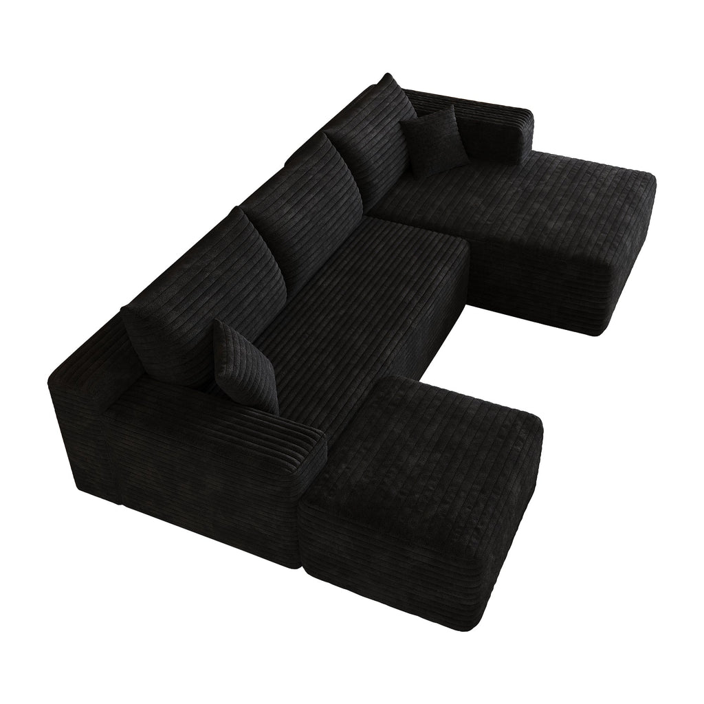 Dark upholstered sectional sofa viewed at angle with chaise seating and back pillows.