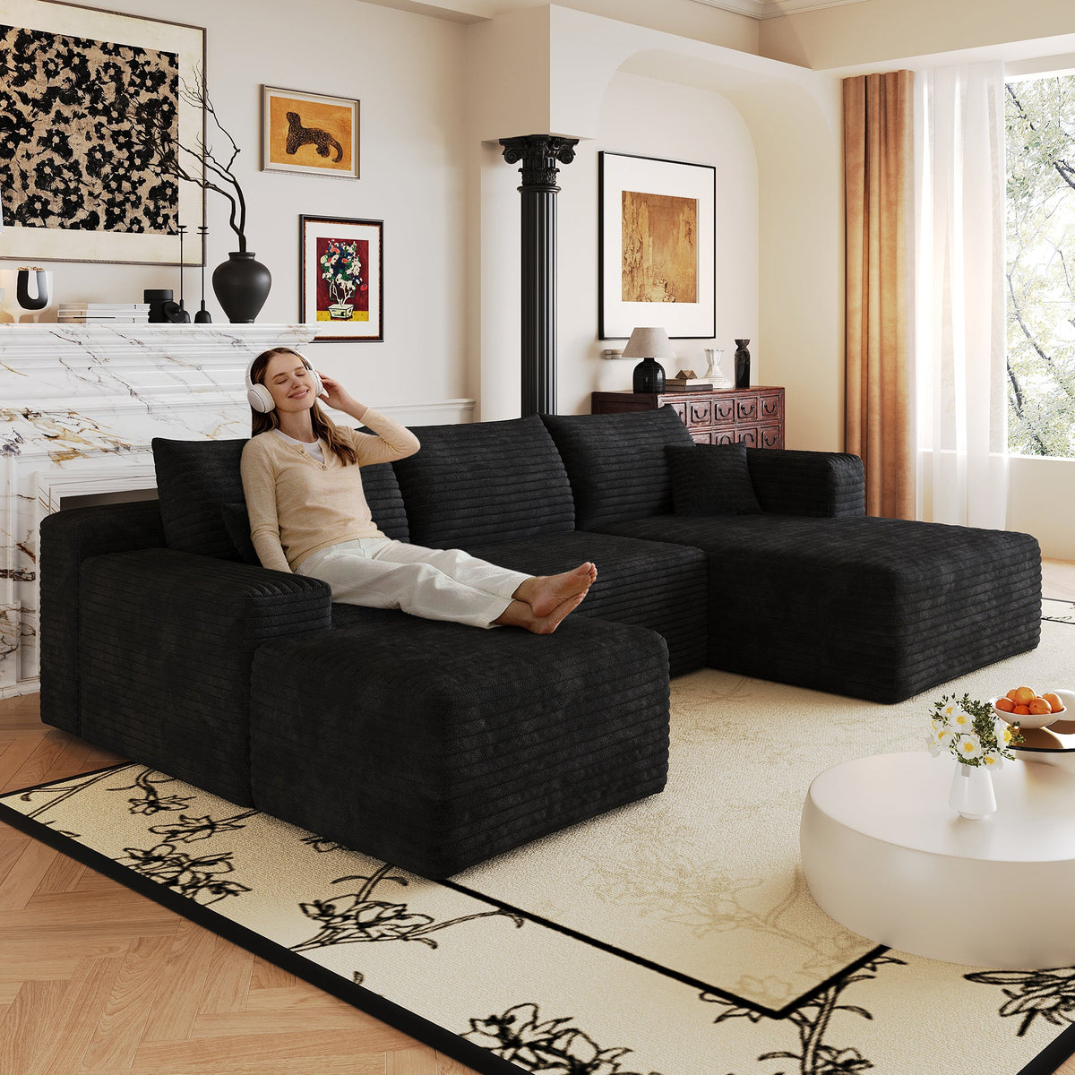 Dark upholstered L-shaped sectional sofa with back cushions and ottoman chaise.