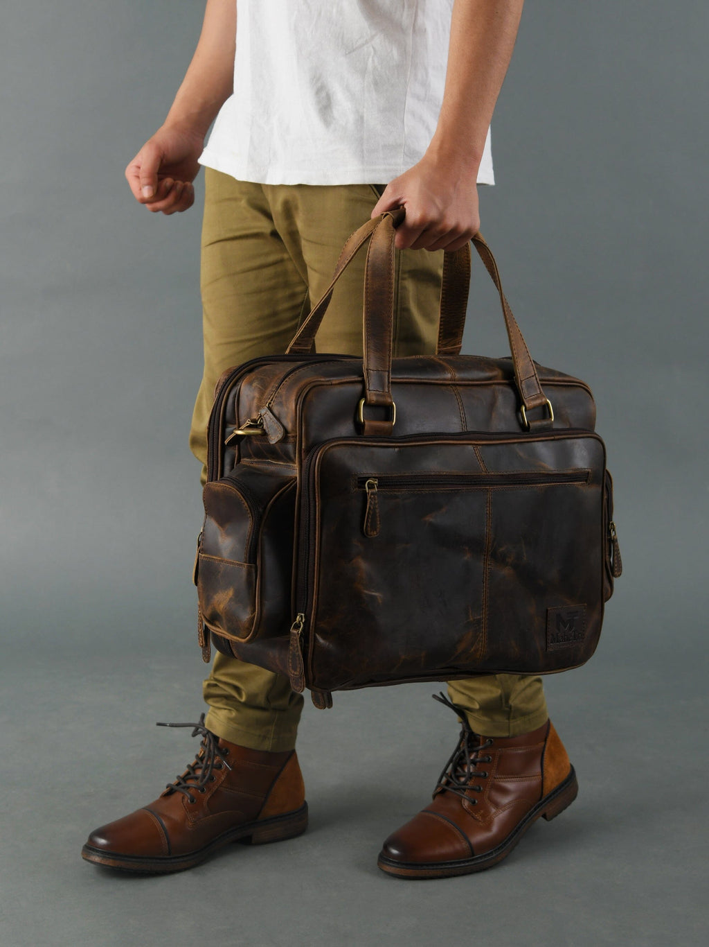 Brown leather briefcase worn over the shoulder with front zip pocket detailing