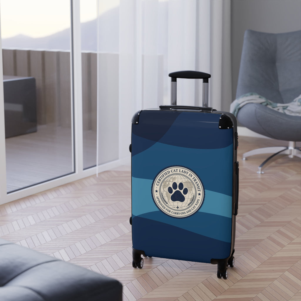 Hard-shell suitcase, blue with paw emblem, upright on four wheels