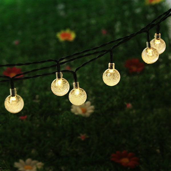 Outdoor solar fairy light string with round globe bulbs, warm white glow outdoors