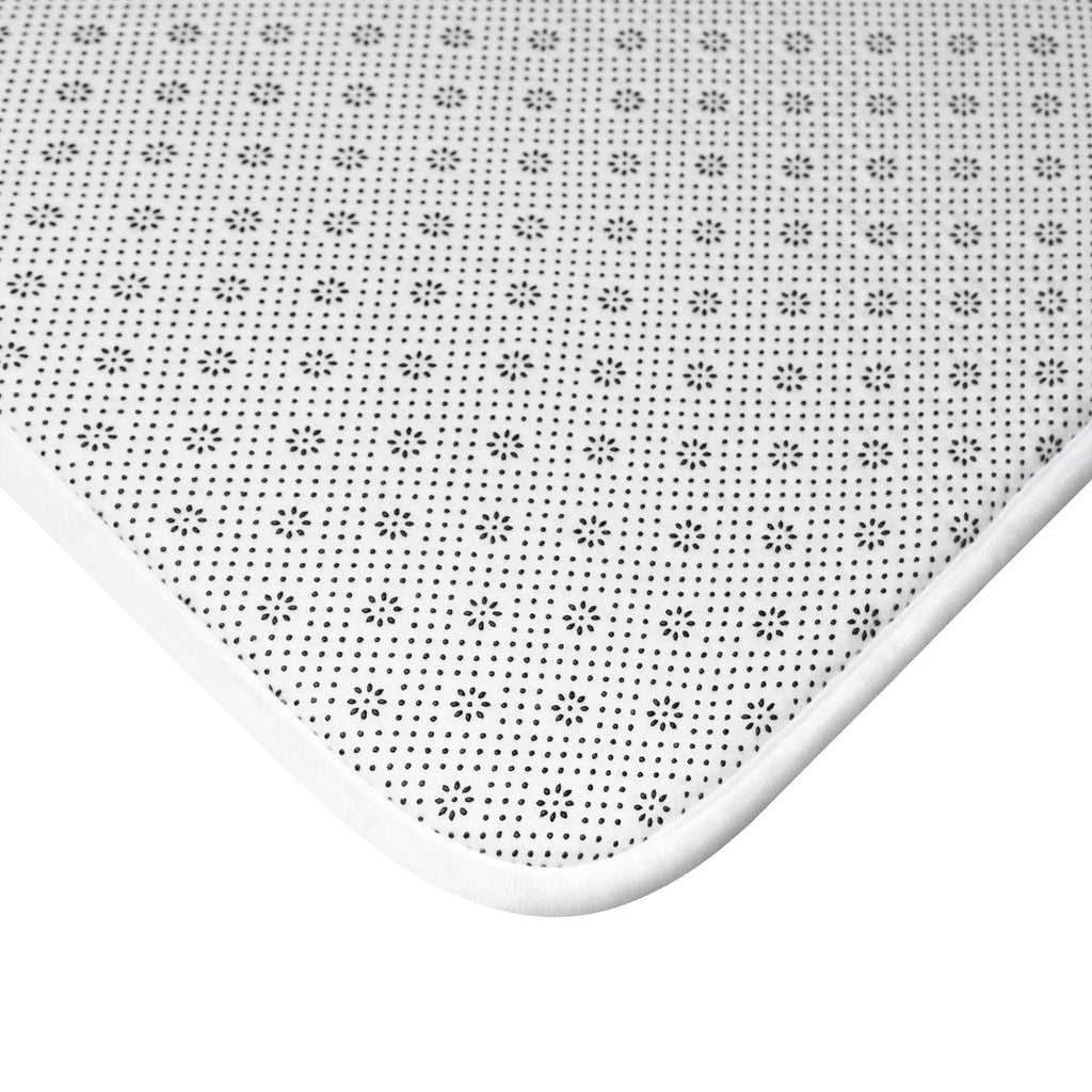 Dotted bath mat surface with small star-like pattern and white fabric edge