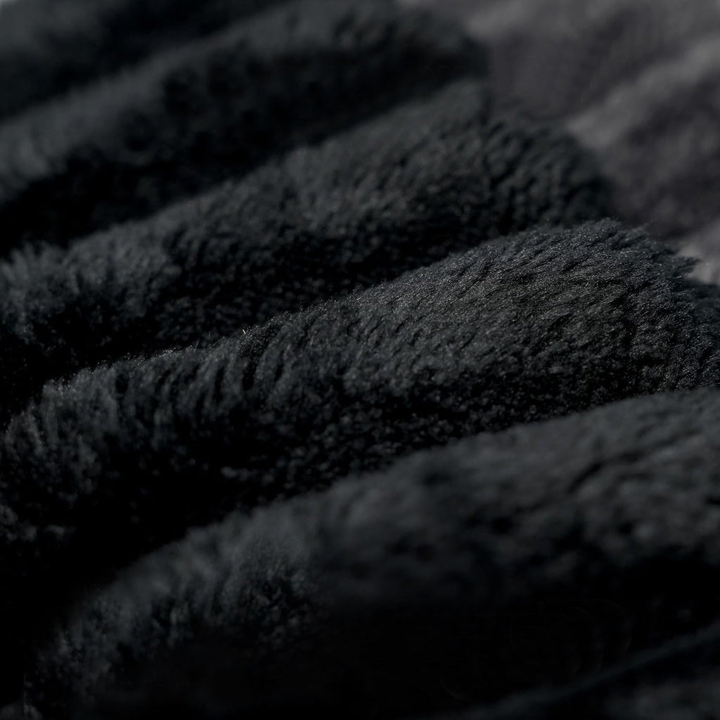 Black plush corduroy fabric close-up with textured upholstery