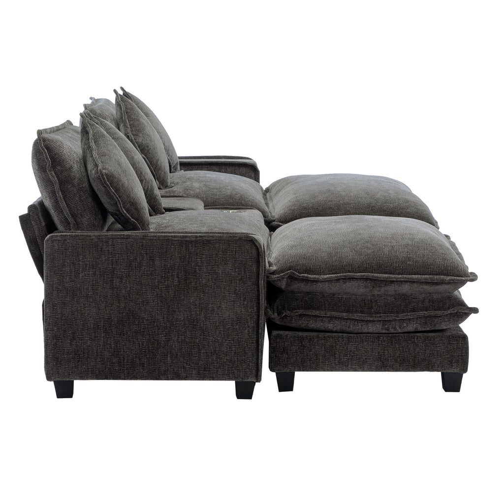 Dark gray sectional sofa with ottoman chaise and layered seat cushions, four pillows