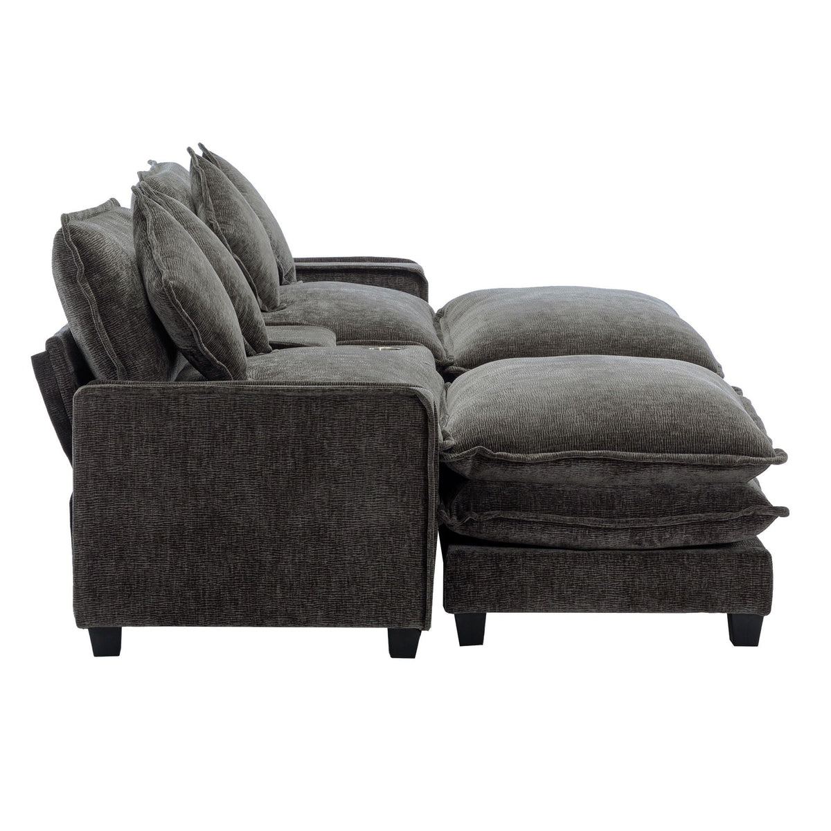 Dark gray sectional sofa with ottoman chaise and layered seat cushions, four pillows