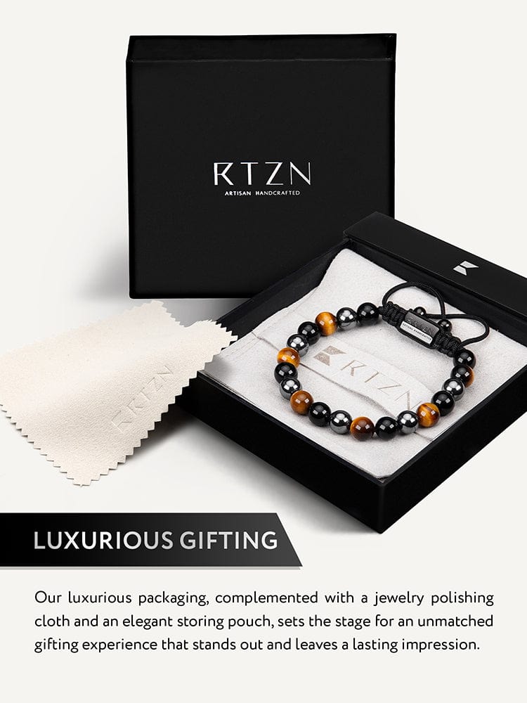 Bracelet in gift box with black and gold-toned bead design and braided cord