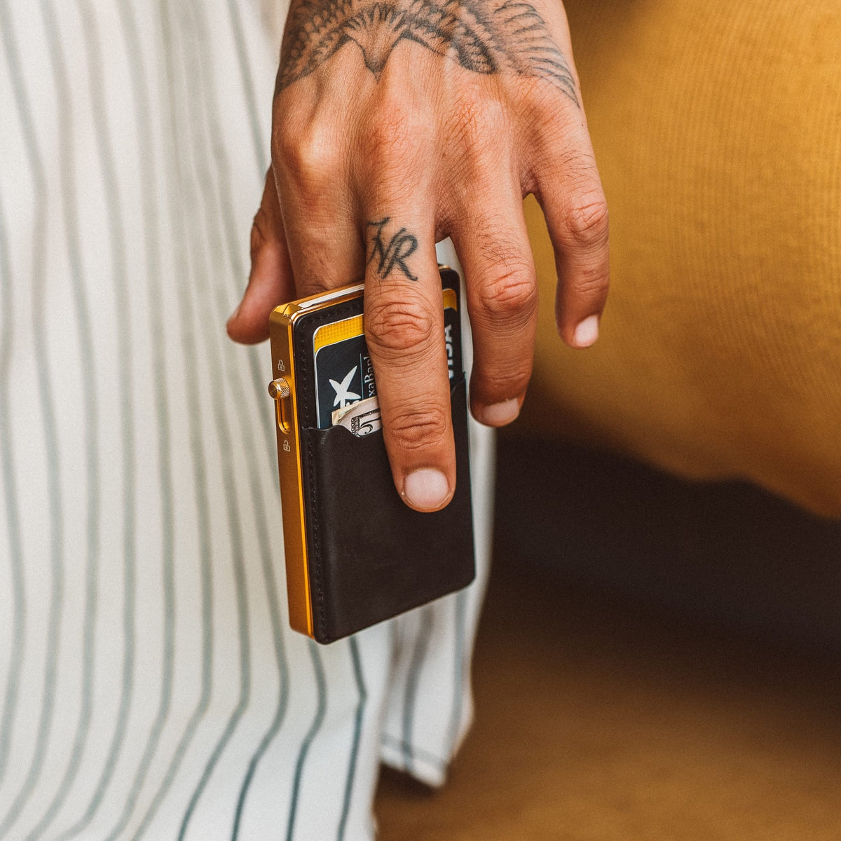 Mod wallet with black card holder insert and gold-tone edges, held upright