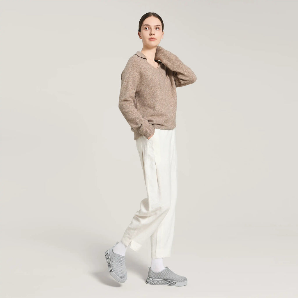 Gray 3D-printed slip-on sneakers on model with white pants and crew socks