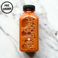 Organic Flow botanical beverage bottle, orange liquid, black cap, front label visible.