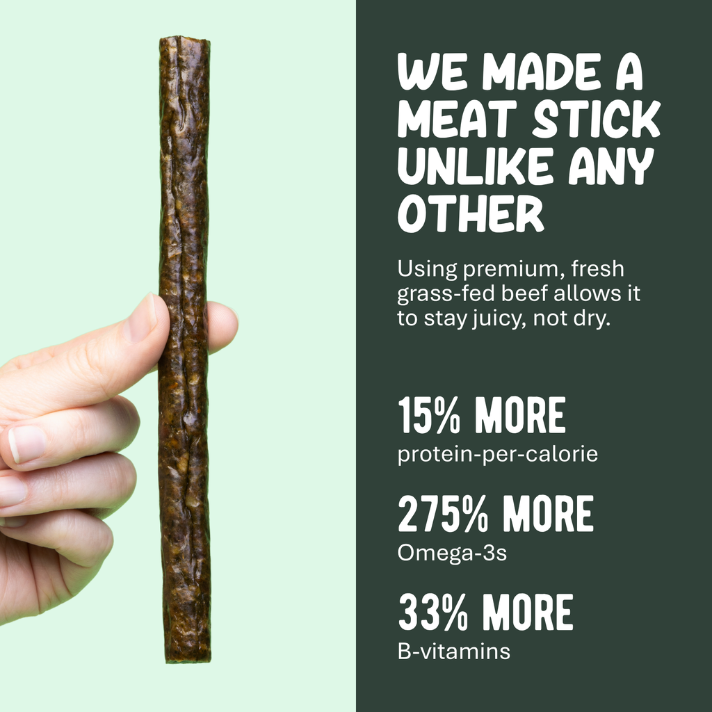 One dark brown beef meat stick held upright by a hand
