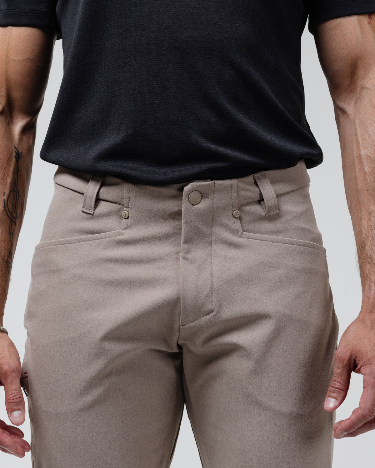 Tan chino pants close-up of waistband, button closure, and belt loops