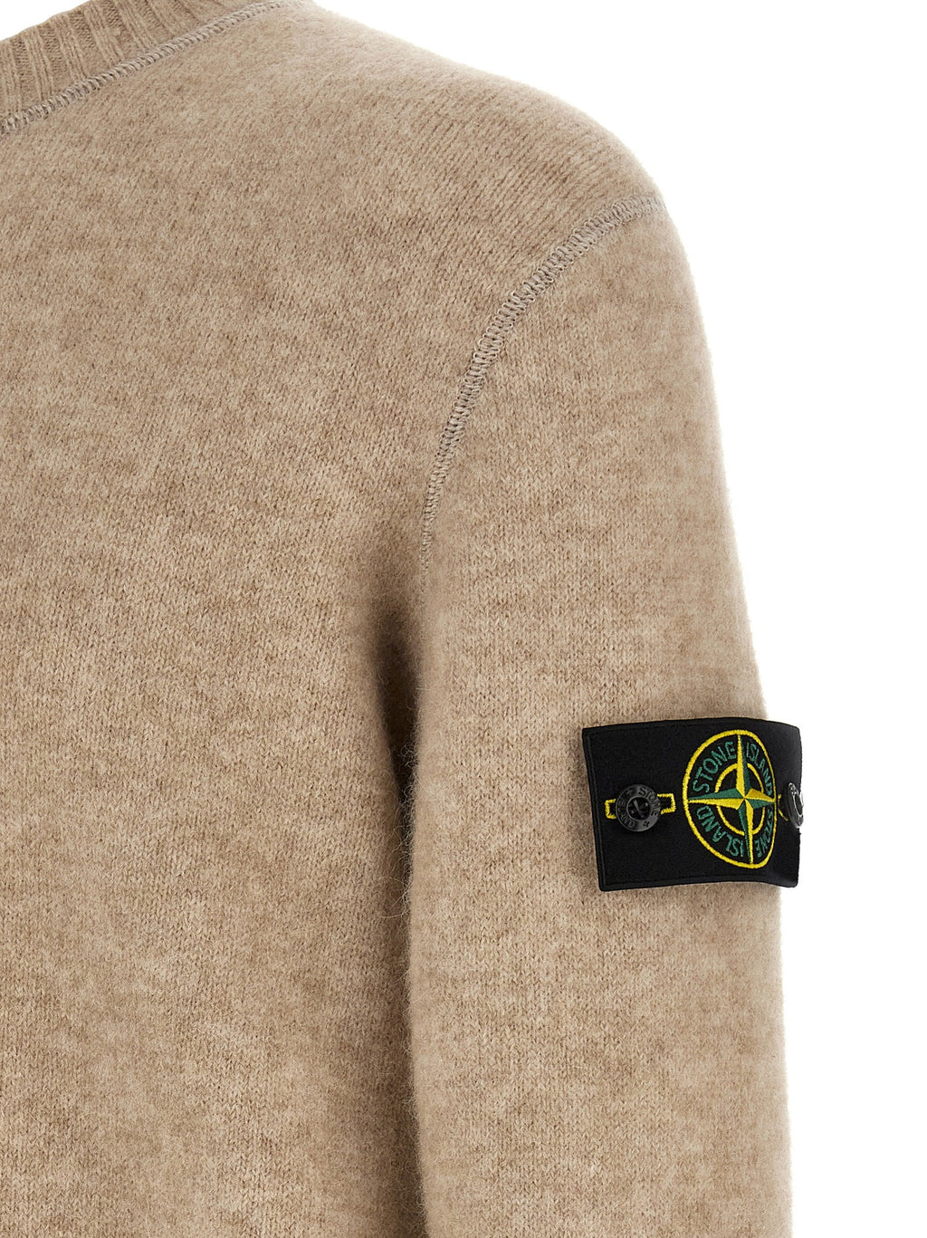 Beige wool cardigan shoulder with black Stone Island patch and ribbed knit.