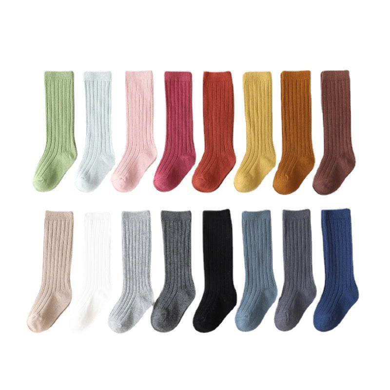 Set of pairs of mid-calf ribbed baby socks in multiple solid colors.