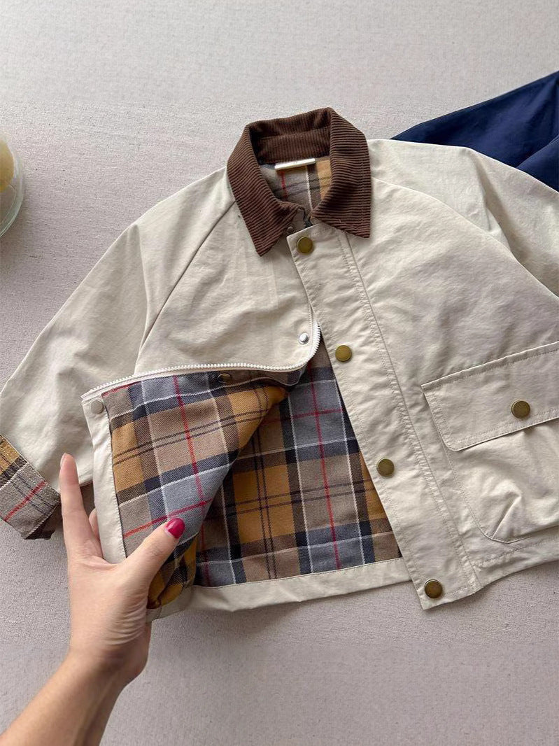 White jacket with brown ribbed collar, button front, and plaid lining panel