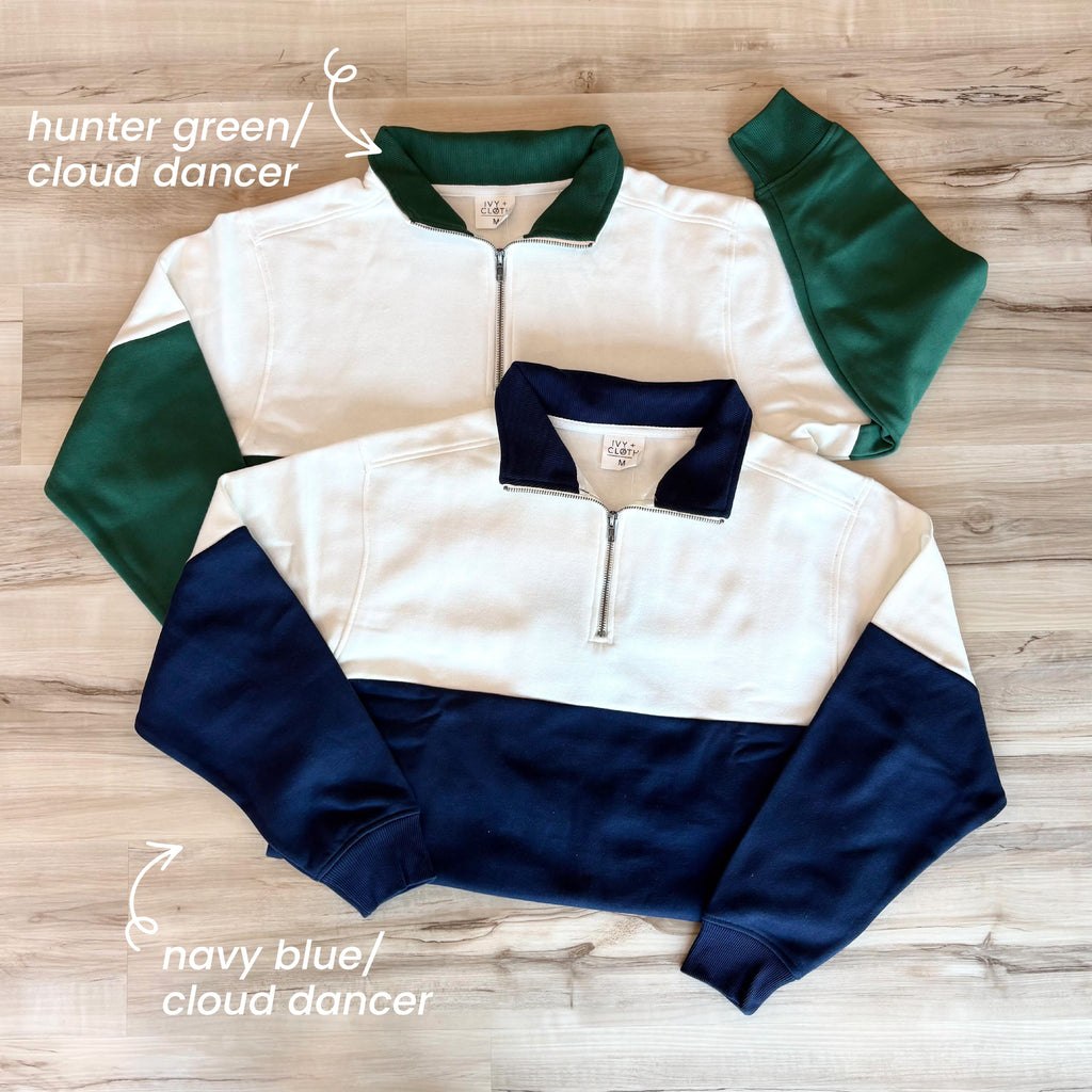 Colorblock quarter-zip pullover laid flat, white and navy long sleeves