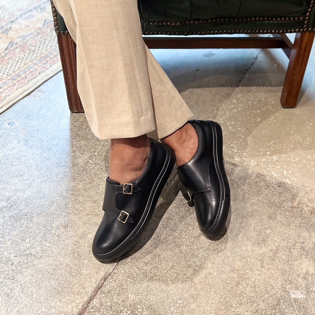 Black slip-on loafers with two buckles and low-profile sole