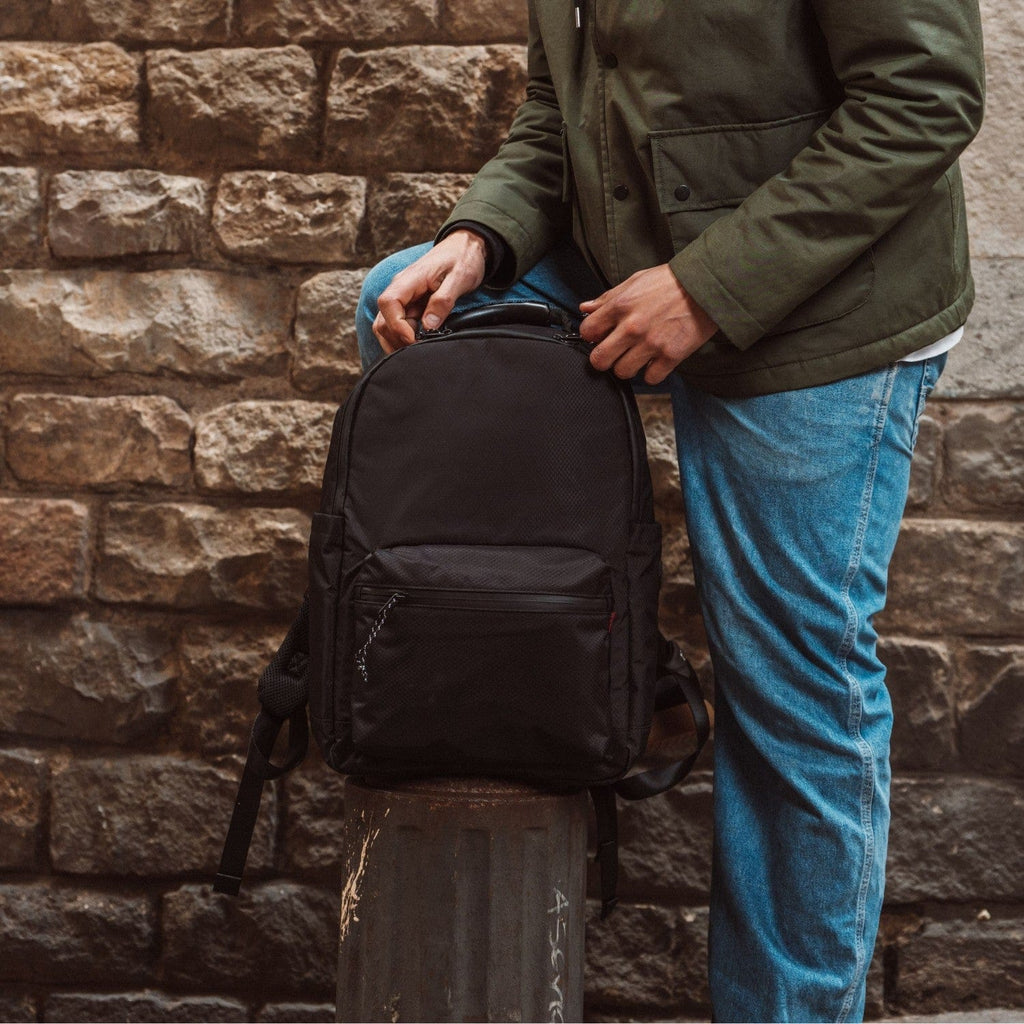 Black backpack with front zipper pocket and top handle.