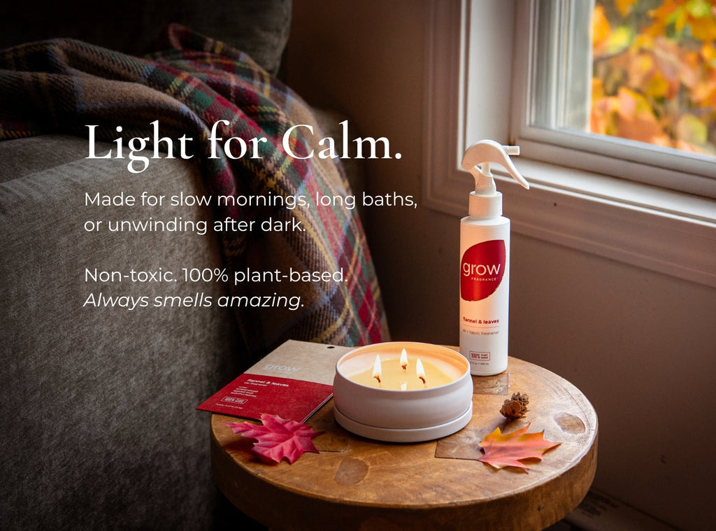 Lit 3-wick candle in a white round jar on a wooden table