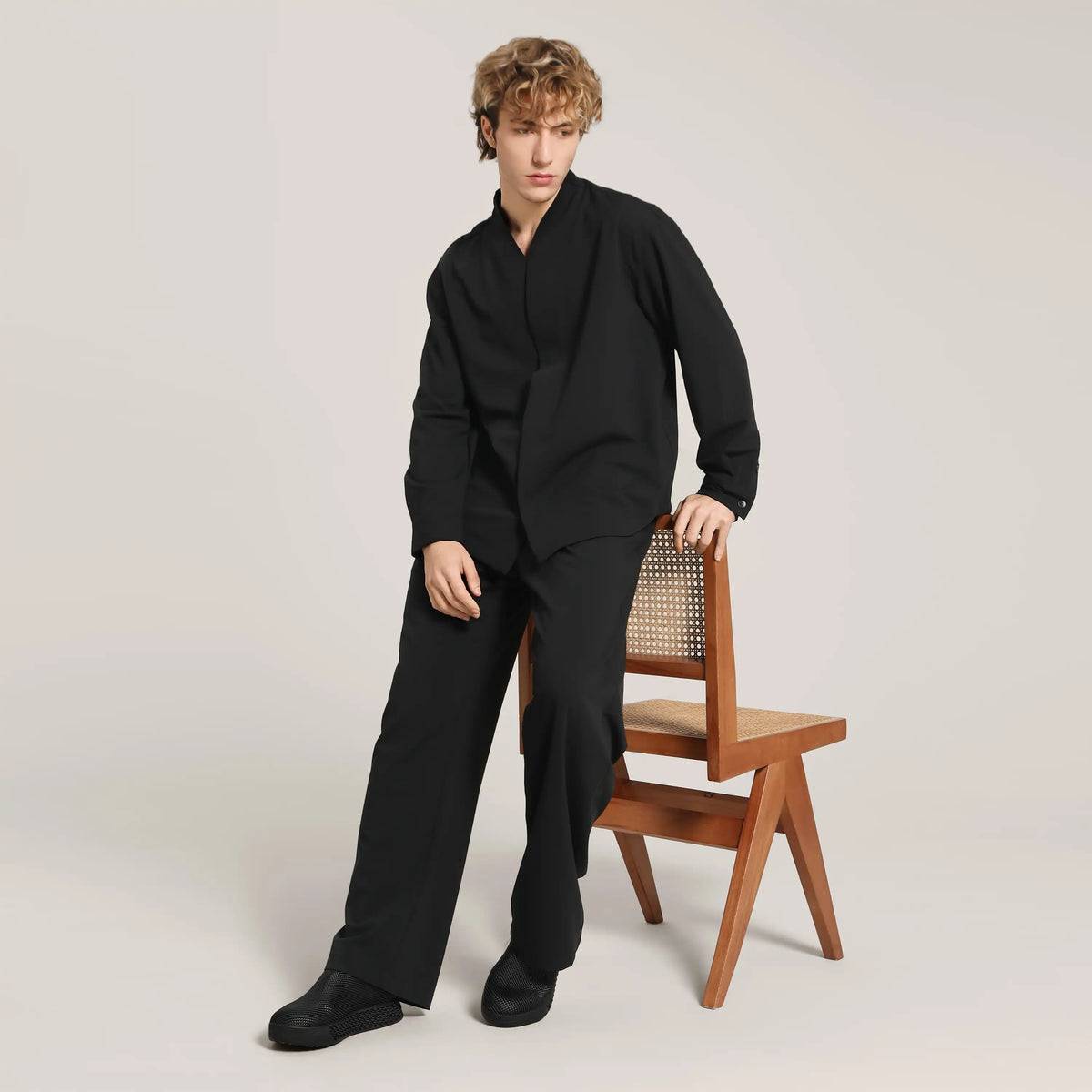 Black 3D printed slip-on sneakers on model wearing black outfit