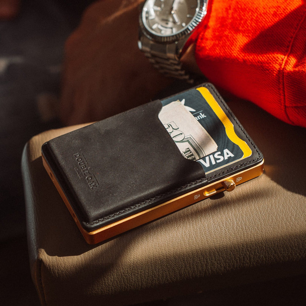Black leather card wallet with metal edge and Visa card slot, angled view