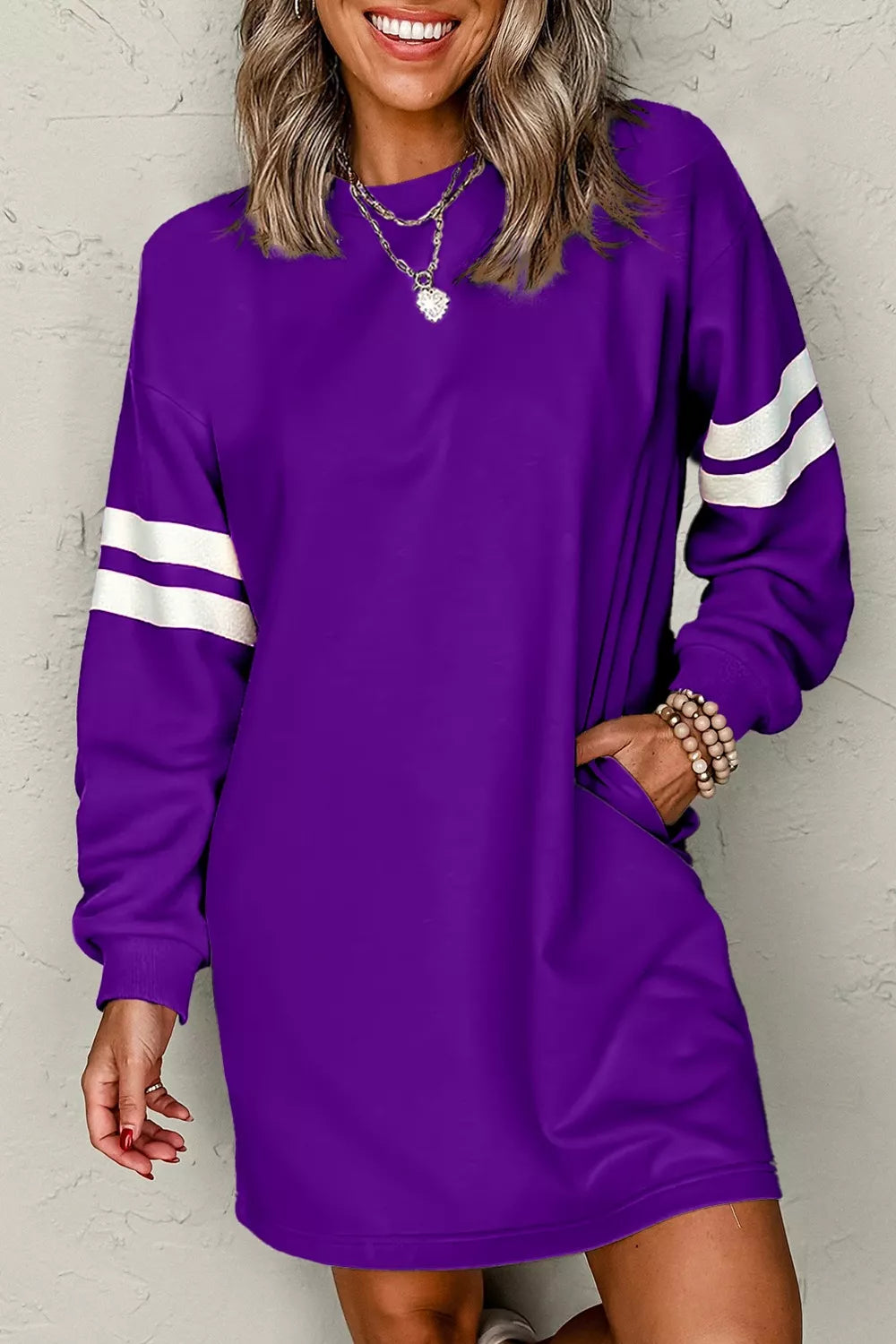 Purple sweatshirt dress with long sleeves, white striped arm bands, straight hem.