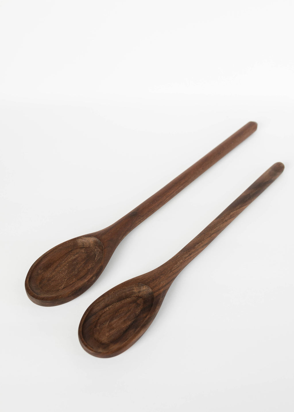 Two wooden serving spoons with deep oval bowls and long handles.