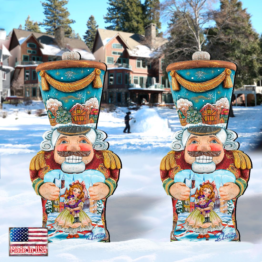 Two painted nutcracker lawn decorations with blue tops, red coats, holding dolls, in snow