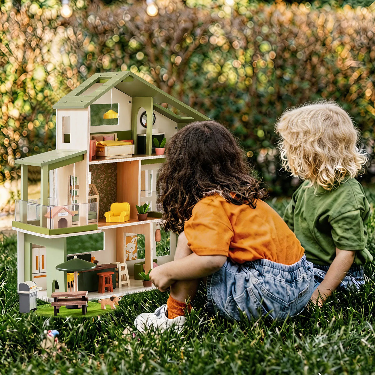 Green Tiny Land dollhouse with furnished rooms, displayed in an outdoor play setting