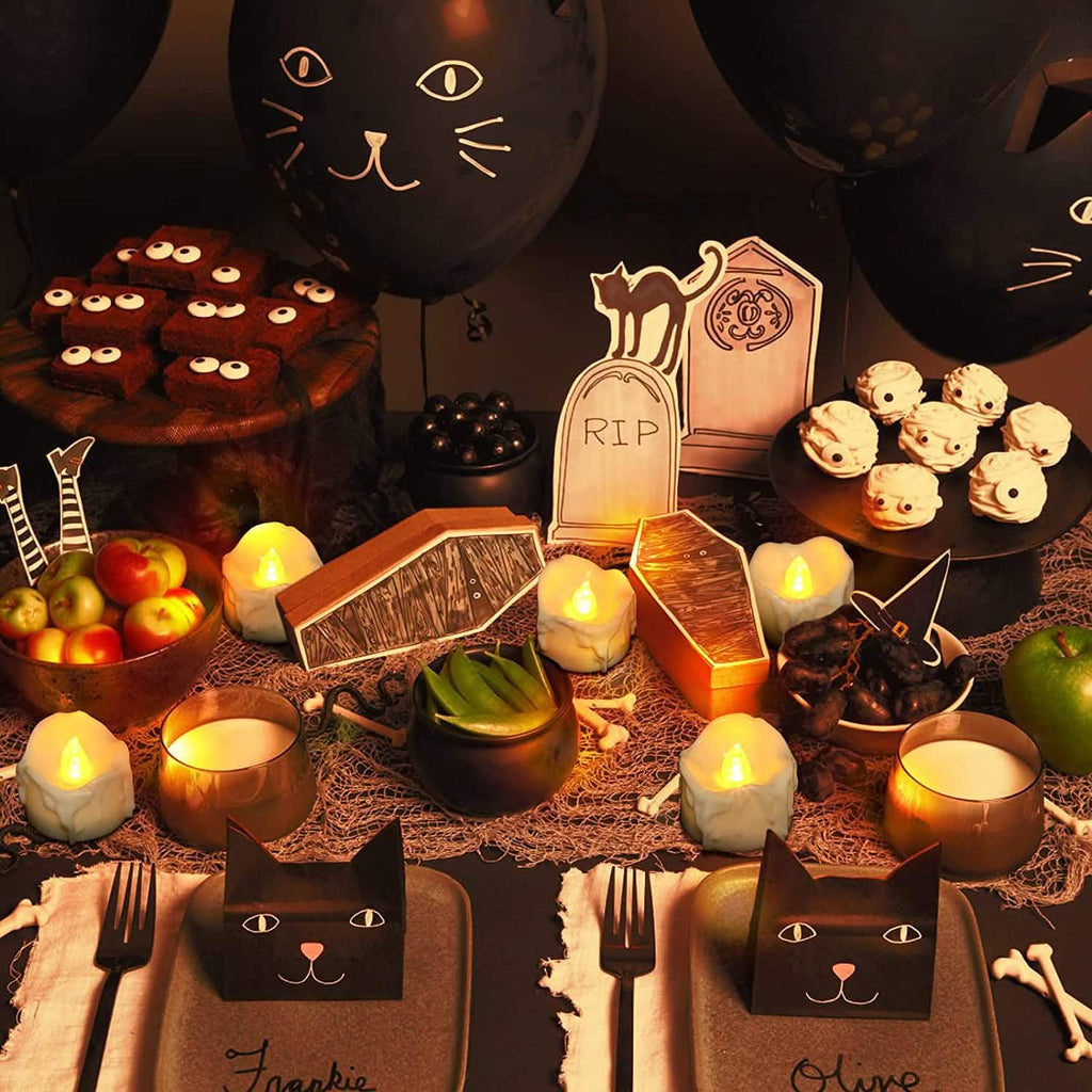 White LED candles with glowing flames on a Halloween dining table