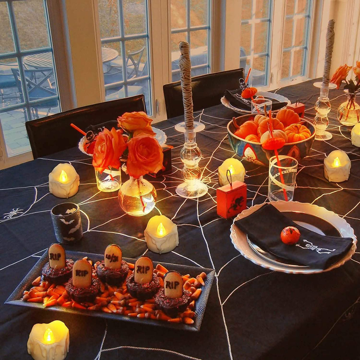 White LED candles with glowing flames on a decorated party table