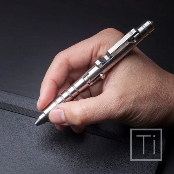 Bolt-action pen with silver metal body and dark accents, held in hand