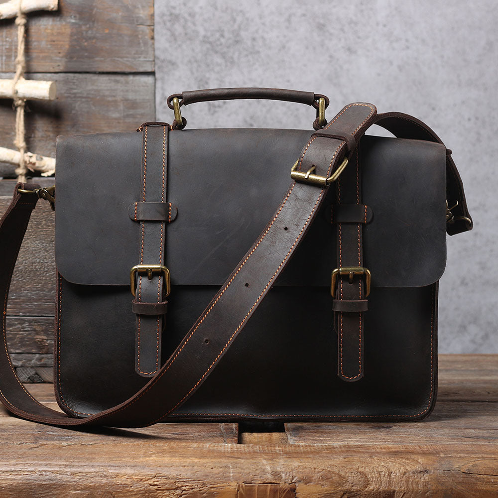 Brown leather messenger bag with long crossbody strap and top handle, front flap