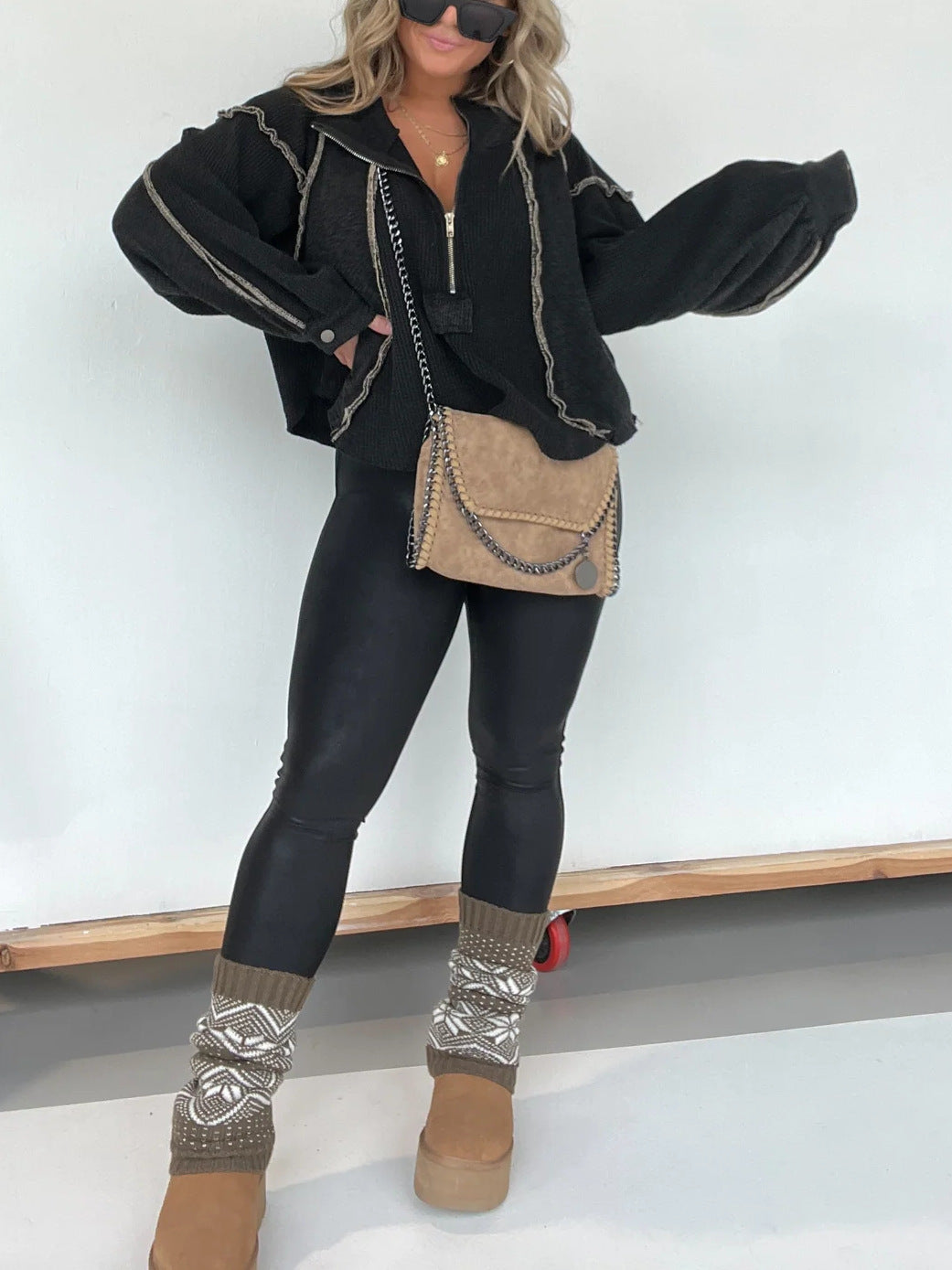Black quarter-zip sweater with contrast rope trim and relaxed short silhouette