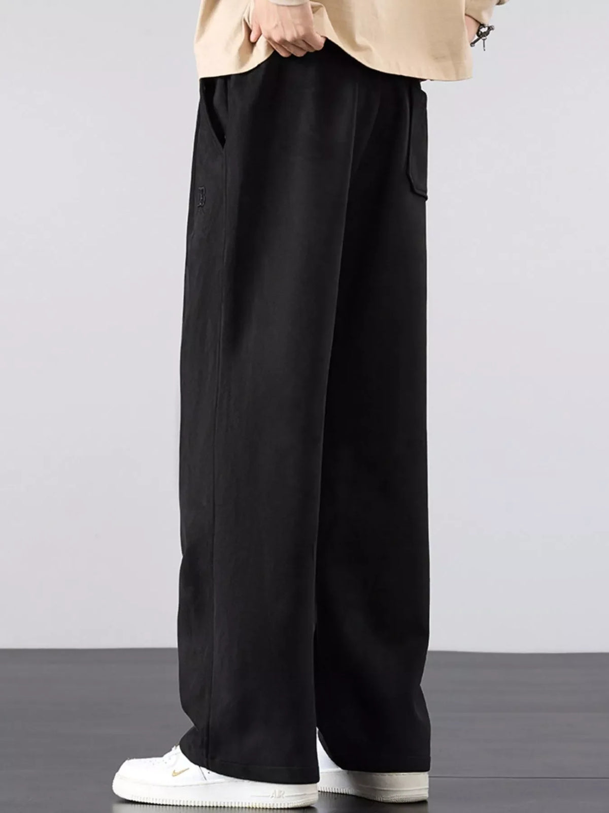 Men's black loose drawstring pants with wide legs and elastic waistband