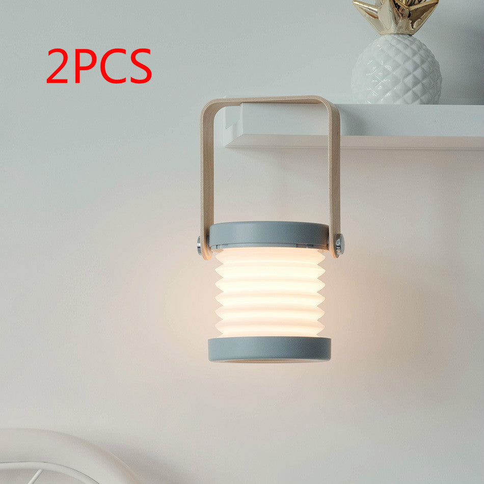 Foldable LED night light lantern glowing warm light, tan handle, ribbed white shade