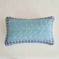 Turquoise lumbar pillow sham with light print and blue geometric patchwork border