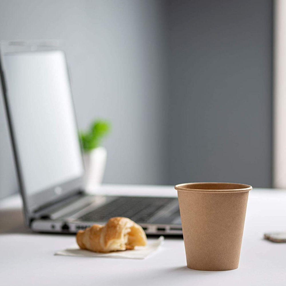 Single unbleached kraft hot coffee cup on table near a laptop