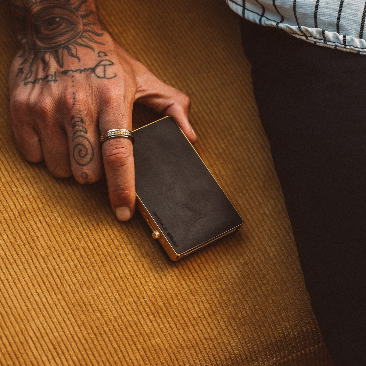 Mod wallet with black card window and gold-tone frame, close-up on fabric