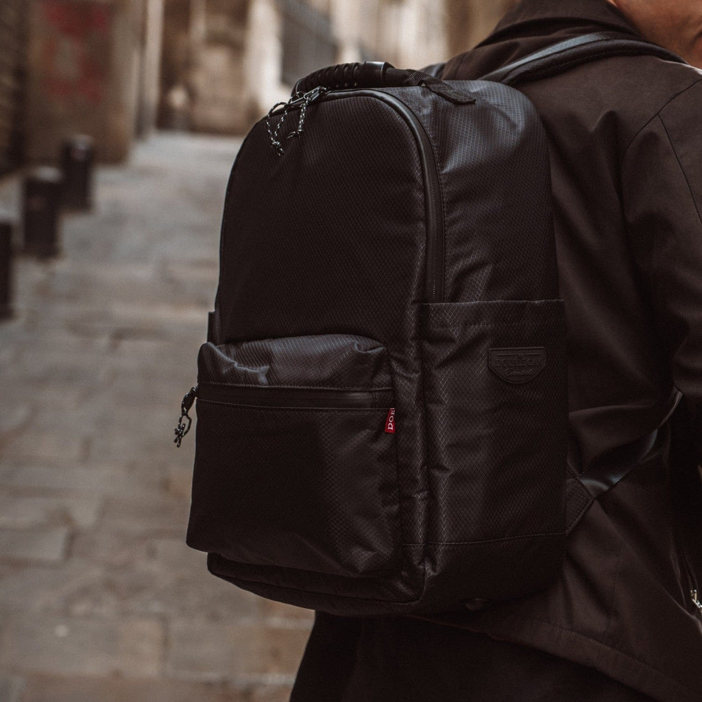 Black fabric backpack with front zip pocket and top handle straps