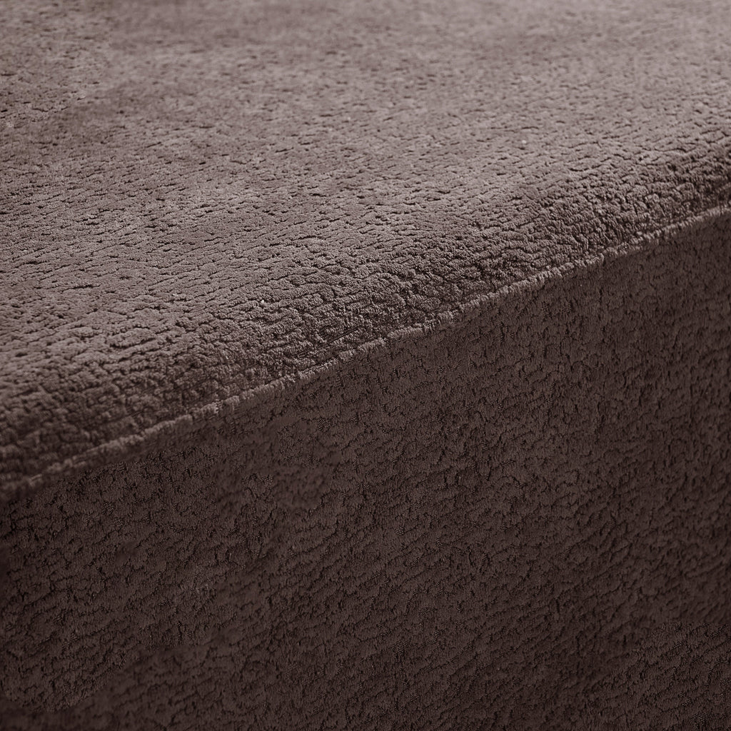 Brown upholstery fabric close-up with soft napped texture and visible seam edge