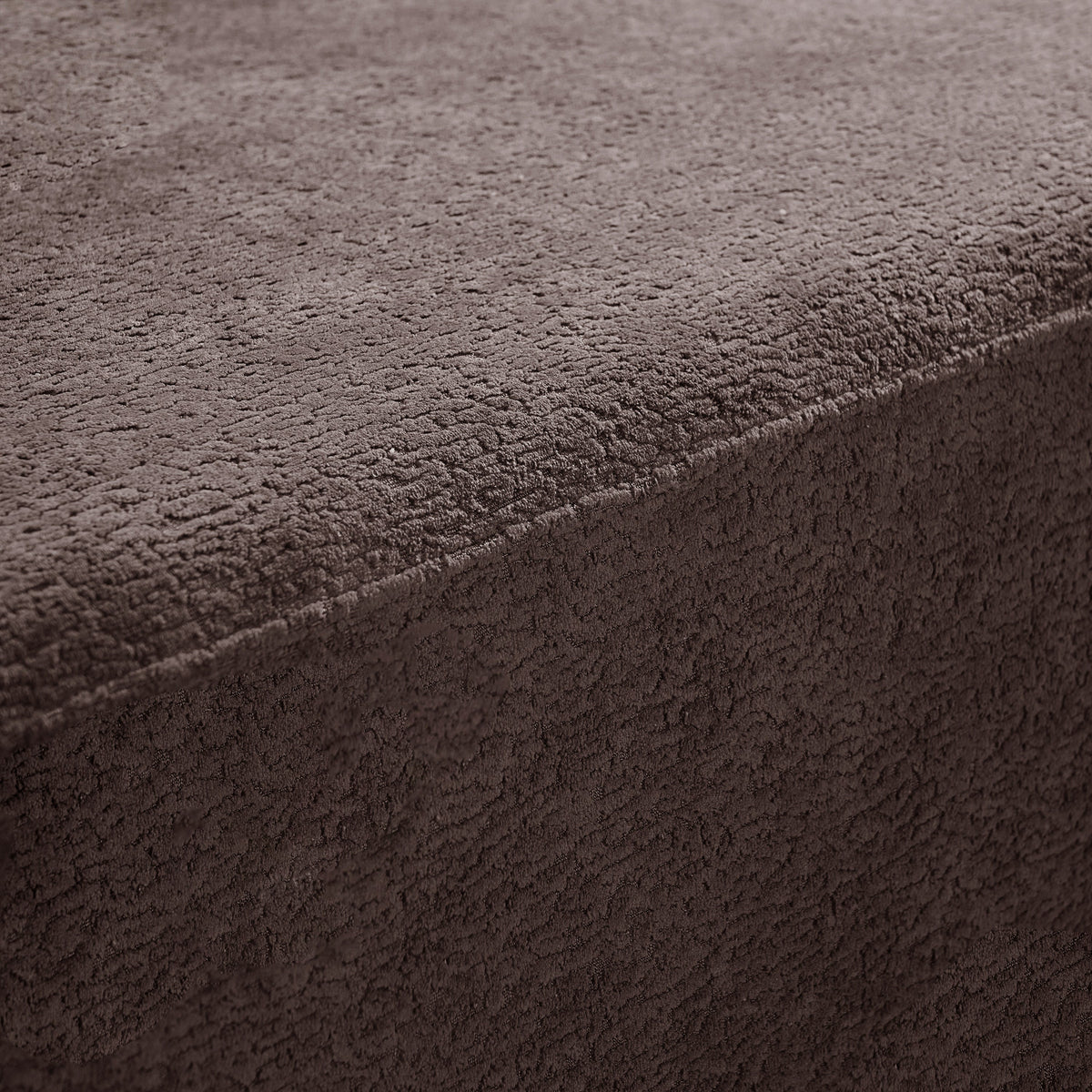 Brown upholstery fabric close-up with soft napped texture and visible seam edge